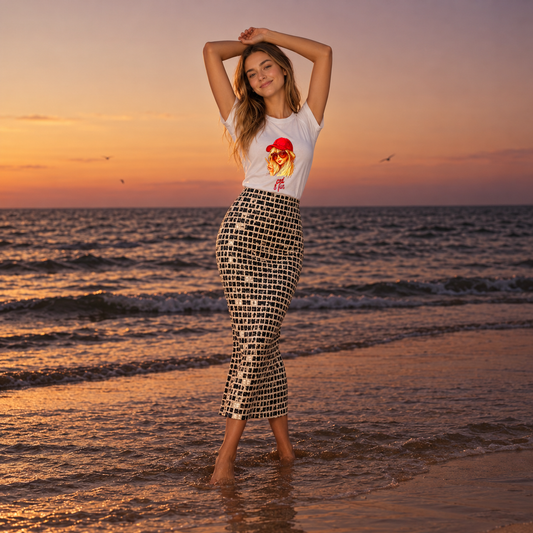 Female model wearing a white graphic tee with a retro girl illustration while standing by the sea at sunset
